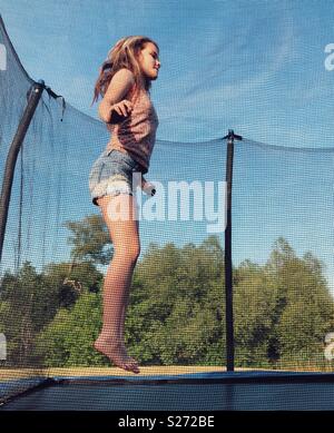Tween girl Springen auf einem Trampolin Stockfoto