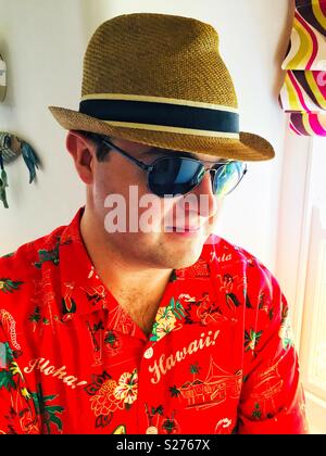 Ein junger, schöner Mann in bunten Hawaii Hemd und Sonnenbrille Stockfoto