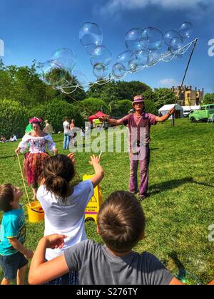 Mann erstellen riesige Seifenblasen, unterhaltsame Kinder in Sherborne Castle Country Fair, Sherbourne, Dorset, England Stockfoto