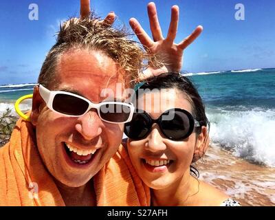 Junge blonde Mann und brünette Frau hohe Energie nassen Spaß in der Sonne, Surf, Sand und Strand in tropischen Paradies Stockfoto