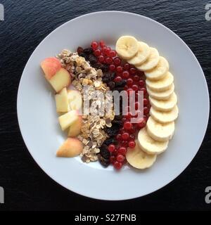 Erhöhten Blick auf weiße Platte mit Müsli und ausgewählte Früchte Stockfoto