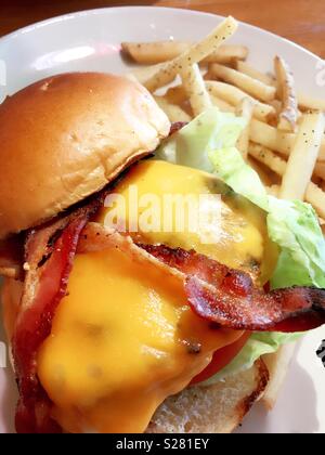 Speck Käse Hamburger und Pommes frites serviert in einem Diner, USA Stockfoto