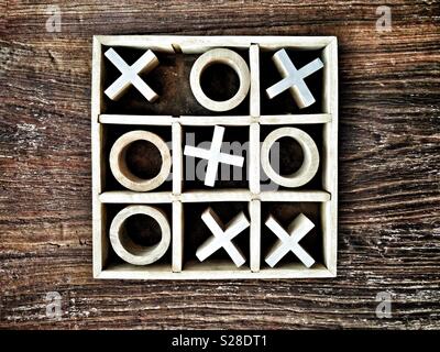 Nullen und Kreuze aus Holz oder Tic-Tac-Toe Spiel auf hölzernen Tischplatte; Kreuze zu gewinnen. Stockfoto