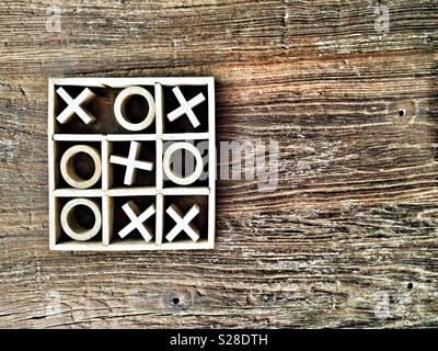 Holz- Tic-tac-toe oder Nullen und Kreuze Spiel auf eine körnige Tischplatte mit kopieren. Kreuze zu gewinnen. Stockfoto