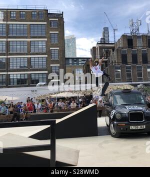 Mann springen über Taxi auf Skateboard Stockfoto