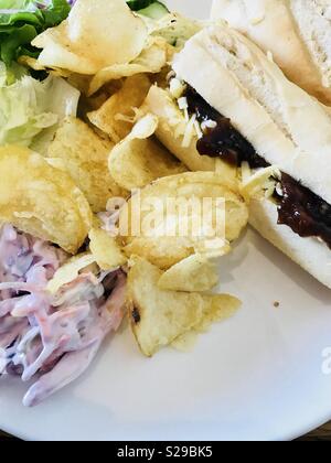 Mit Käse und eingelegten Gurken Baguette mit Salat, Krautsalat und Chips Stockfoto