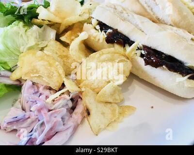 Mit Käse und eingelegten Gurken Baguette mit Salat und Pommes Stockfoto