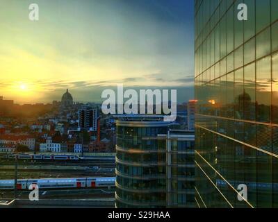 Sonnenaufgang über der Stadt und die im Büro Windows wider Stockfoto