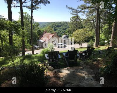 Das Sitzen auf dem Rasen vor der Crescent Hotel, mit Blick auf St. Elisabeth der Katholischen Kirche und die Ozark Berge in Eureka Springs, Arkansas Stockfoto