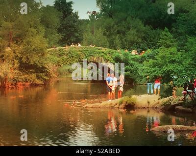 Touristen sammeln am Teich vor Gapstow Brücke, Central Park, New York City, USA Stockfoto