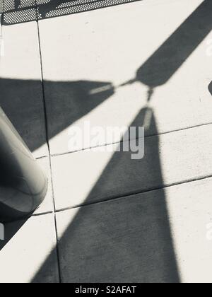 Abstrakte Kunst der dunklen, harten Schatten auf dem Zementboden im Park - Schwarz-Weiß-Foto Stockfoto