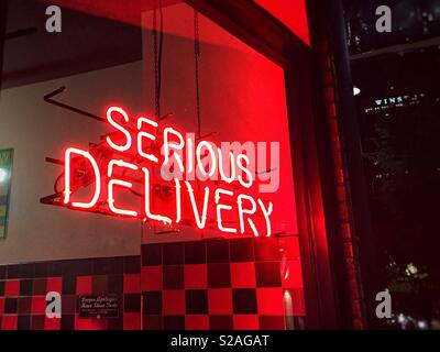 Schwere Lieferung. Rote Leuchtreklame in einem Fast-Food-Restaurant. Stockfoto