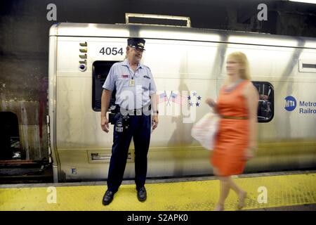 Rail Dirigent lächelnd auf einen weiblichen Passagier ihn vor seinen Zug am Grand Central Station NEW YORK stehend Stockfoto