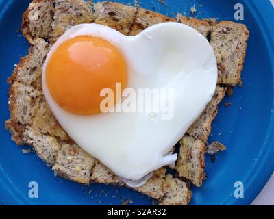 Spiegelei auf Toast. Das Ei ist in der Form eines gesunden Herzens zu implizieren eine gesunde Ernährung und gutes Wohlbefinden.. Stockfoto