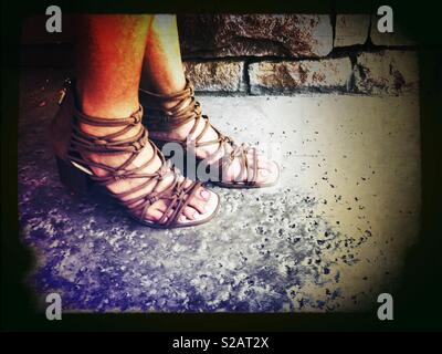 Frau das Tragen leicht braunen Riemchen Gladiator Sandalen draussen auf der Terrasse an einem heißen Sommertag Stockfoto