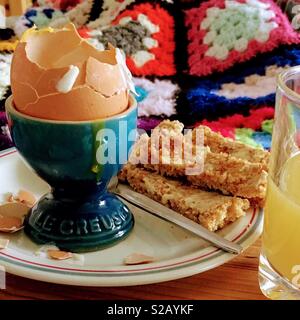 Frühstück im Bett - gekochte Eier, Toast, Orangensaft. Stockfoto