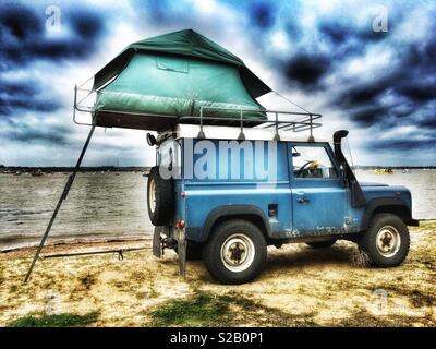 Land Rover mit Zelt an Dachträger Stockfoto