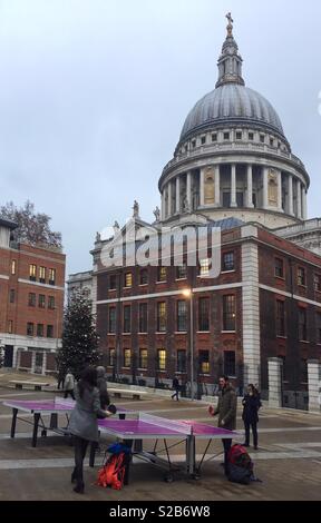 Touristen spielen Tischtennis im Paternoster Square in der Nähe von St Paul's Cathedral zu Weihnachten Stockfoto