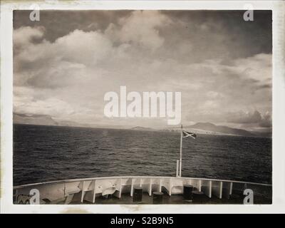 MV-Loch Seaforth kreuzt den Minch zwischen Stornoway und Ullapool in Schottland im September. Vor der Fähre, die Saltire und Ullapool Hügel. Sepia. Stockfoto