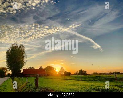 Idyllische Landschaft Sonnenuntergang mit Wolken in der eindrucksvollen und bunten Himmel malte Stockfoto