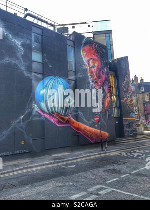 Weibliche holding Globe in den Händen graffiti Streetart in Shoreditch, London von Global Street Art organisiert und von Herrn erstellt. Cenz Stockfoto