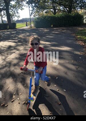 Lächelnd kleine Mädchen bei Scooter Stockfoto