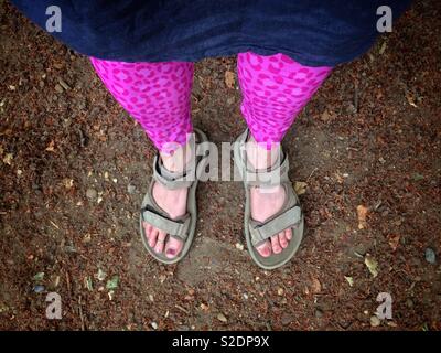 Frau wandern Sandalen und pink Leopard drucken Leggings auf staubigen Boden Stockfoto