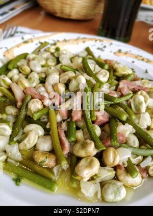 Bohnen mit frischem Knoblauch und Speck. Stockfoto