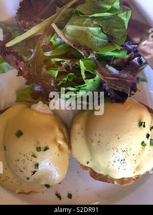 Eier Benedikt und Salat serviert zum Brunch an einem französischen Bistro in Soho, NEW YORK CITY, USA Stockfoto