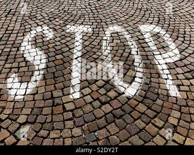 Stop Road Markierung auf einer gepflasterten Straße lackiert Stockfoto