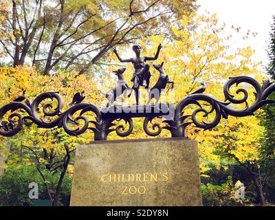 Bronze Skulpturen eines Jungen spielen mit Ziegen auf den Eingang der Kinder Zoo im Central Park, New York City, USA Stockfoto