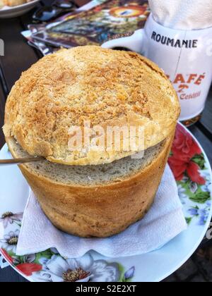 Traditionelle rumänische Bohnensuppe serviert in Brot. Stockfoto