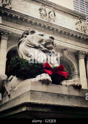 Geduld, die Bibliothek Löwe seine Weihnachten Kranz tragen an der Fifth Avenue Public Library, New York City, USA Stockfoto