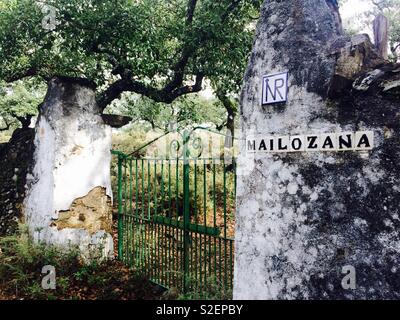 Altmodische Metal Gate in alten verfallenen Steinmauer der Farm in Alajar in Andalusien Spanien Stockfoto