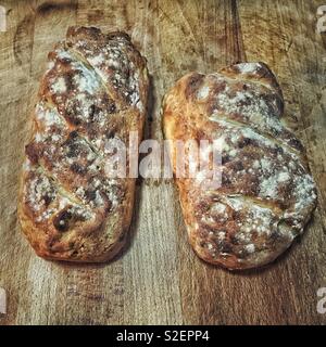Zwei Brote hausgemachtes Brot auf einem hölzernen Schneidebrett. Stockfoto