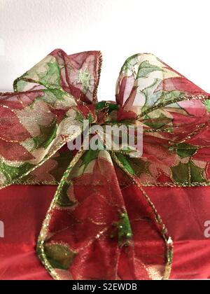 Weihnachtsgeschenk mit einem Fabric Weihnachtsstern Band in eine extravagante Masche gebunden Stockfoto