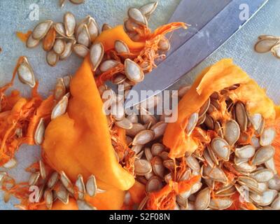 Pulp Küche: Nahaufnahme von Fruchtfleisch und Samen von Butternut Squash auf Schneidebrett mit Messer. Stockfoto