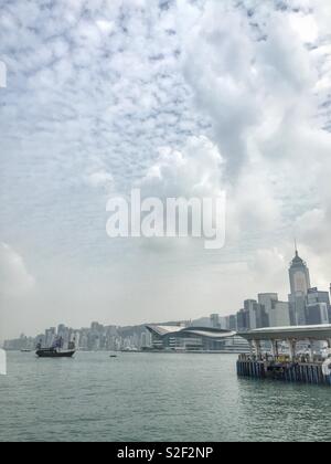 Aqua Luna II, ein Nachbau der chinesischen Dschunke für Sightseeing Kreuzfahrten auf den Victoria Harbour, die Hkcec und der hohe Anstieg kommerzielle Gebäude von Wan Chai, Hong Kong Island verwendet Stockfoto