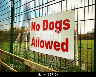 "Keine Hunde erlaubt" Zeichen auf einen Zaun um einen Fußballplatz Stockfoto