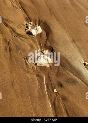 Sand Formen und Kanäle durch Steine und den Atlantischen Ozean erstellt Stockfoto