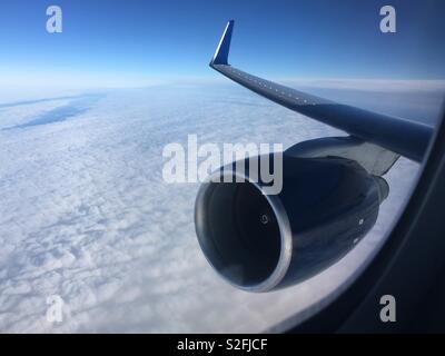 Turbofan Jet Motor und Flügel durch Flugzeuge Fenster beim Flug über den Wolken gesehen Stockfoto