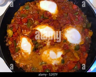 Das Mittelmeer Teller, shakshouka oder Shakshuka - pochierte Eier in einer Sauce aus Tomaten, Paprika und Zwiebeln mit Gewürzen und Knoblauch Stockfoto