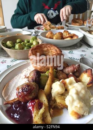 Ein Weihnachtsessen Tabelle mit Platten voller festliche Essen einschließlich Sprößlinge der Türkei und Yorkshire Pudding. Stockfoto