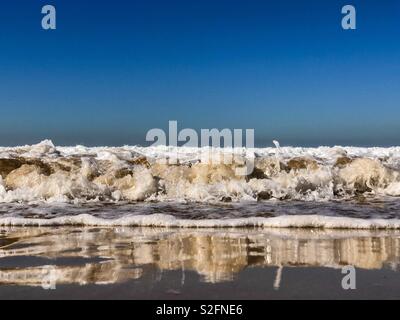 Geringen Winkel von Wellen brechen an einem Sandstrand Marokko Afrika Stockfoto