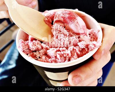 Erdbeereis in Papier Tasse mit Löffel aus Holz Stockfoto