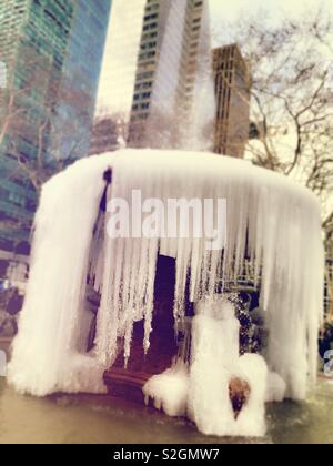 Eiszapfen hängen von der Josephine Shaw Lowell Memorial Fountain im Bryant Park nach einem Kälteeinbruch, NYC, USA Stockfoto