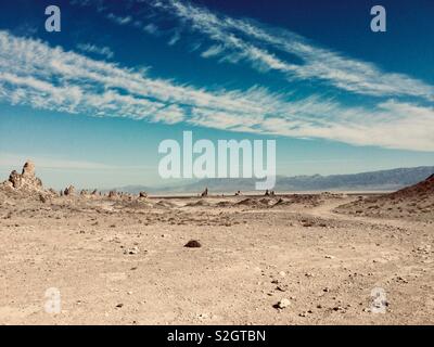 Heiße, trockene Wüste mit Zinnen unter strahlend blauen Himmel mit weißen Wolken. Stockfoto