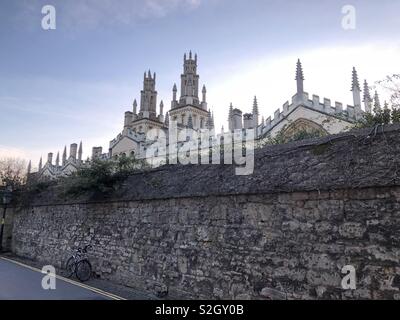 Die Rückseite des All Souls College, Oxford mit einem Vista von einigen der berühmten Dreaming Spires und Türme der Universität über einen alten Lappen gesehen - Steinmauer New College Lane. Stockfoto