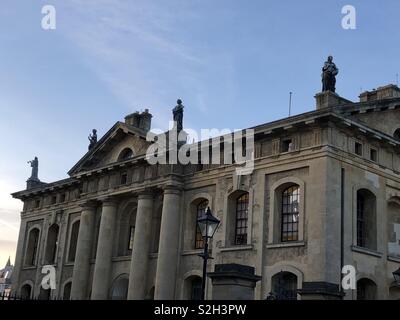 Die Dachlinie und Statuen auf der Clarendon Building, Bodleian Library, Oxford University bei Sonnenuntergang. Stockfoto