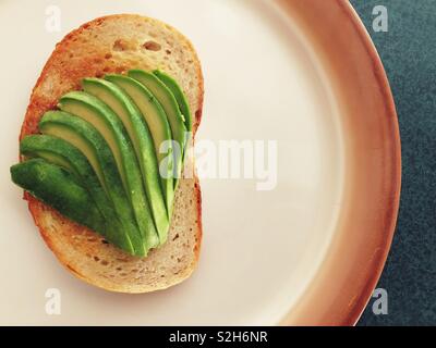 Avocado in Scheiben geschnitten auf Toast auf einer Platte Stockfoto